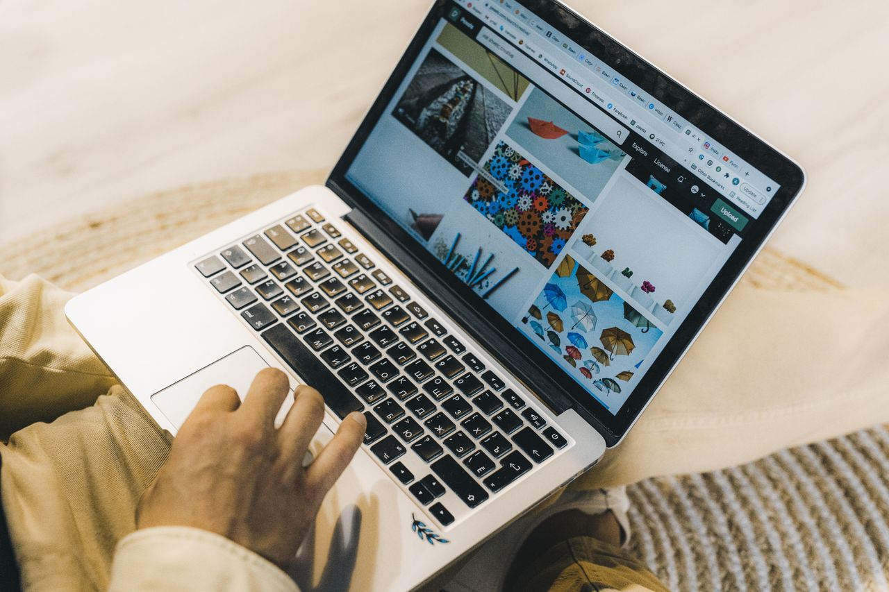 Crafting Captivating Headlines: Your awesome post title goes here A person using a laptop to browse stock photo websites. Freelancing work in a cozy setting.